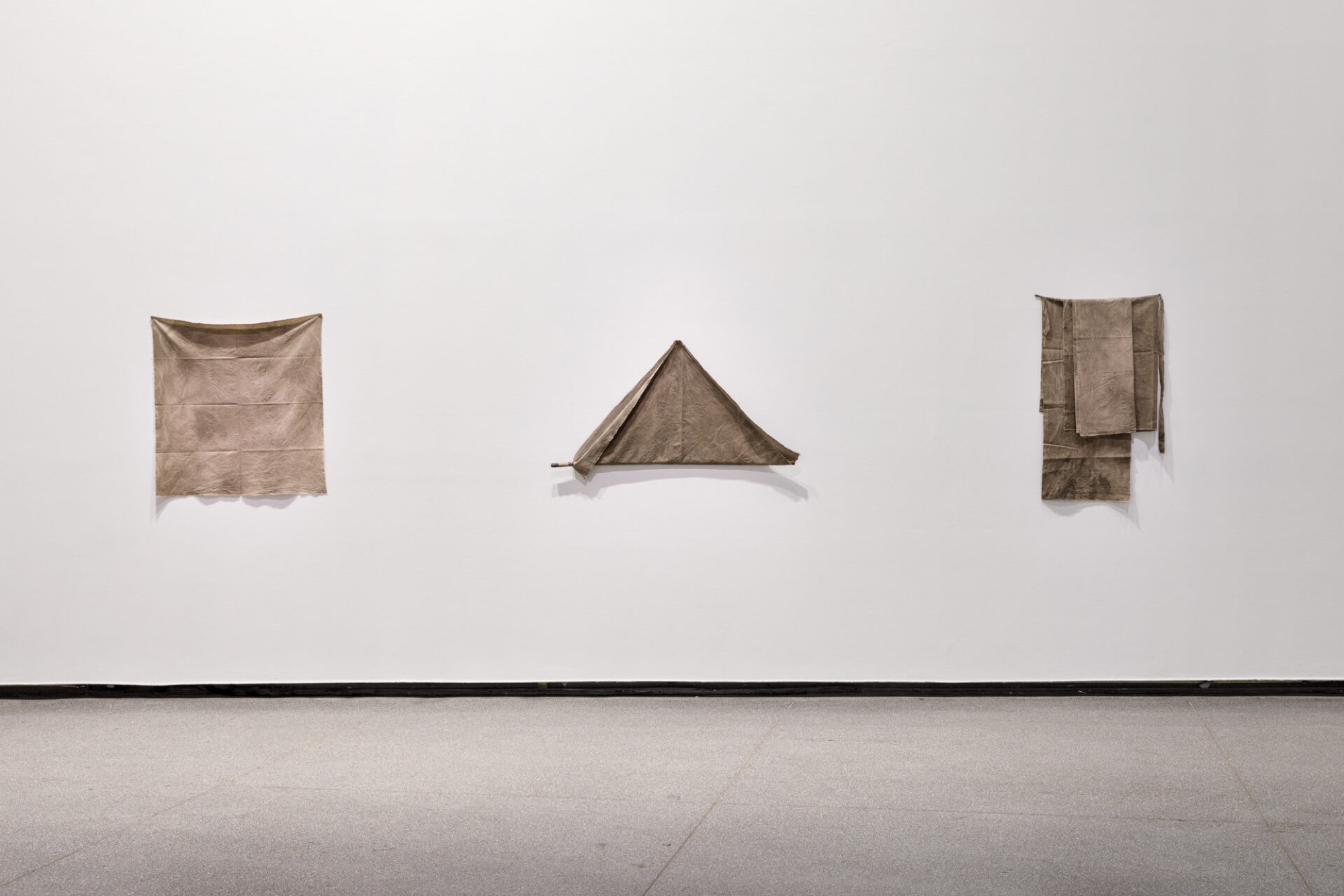 Katie West (Yindjibarndi), Warna/Ground 2018. Calico dyed with eucalyptus and puffball, 100.0 x 100.0 cm;  Hold, 2018. Calico dyed with eucalyptus and puffball, 110.0 x 50.0 cm; Keeping pieces, 2018. Calico dyed with eucalyptus and puffball, dimensions variable. Courtesy the artist. Photograph: Andrew Curtis.