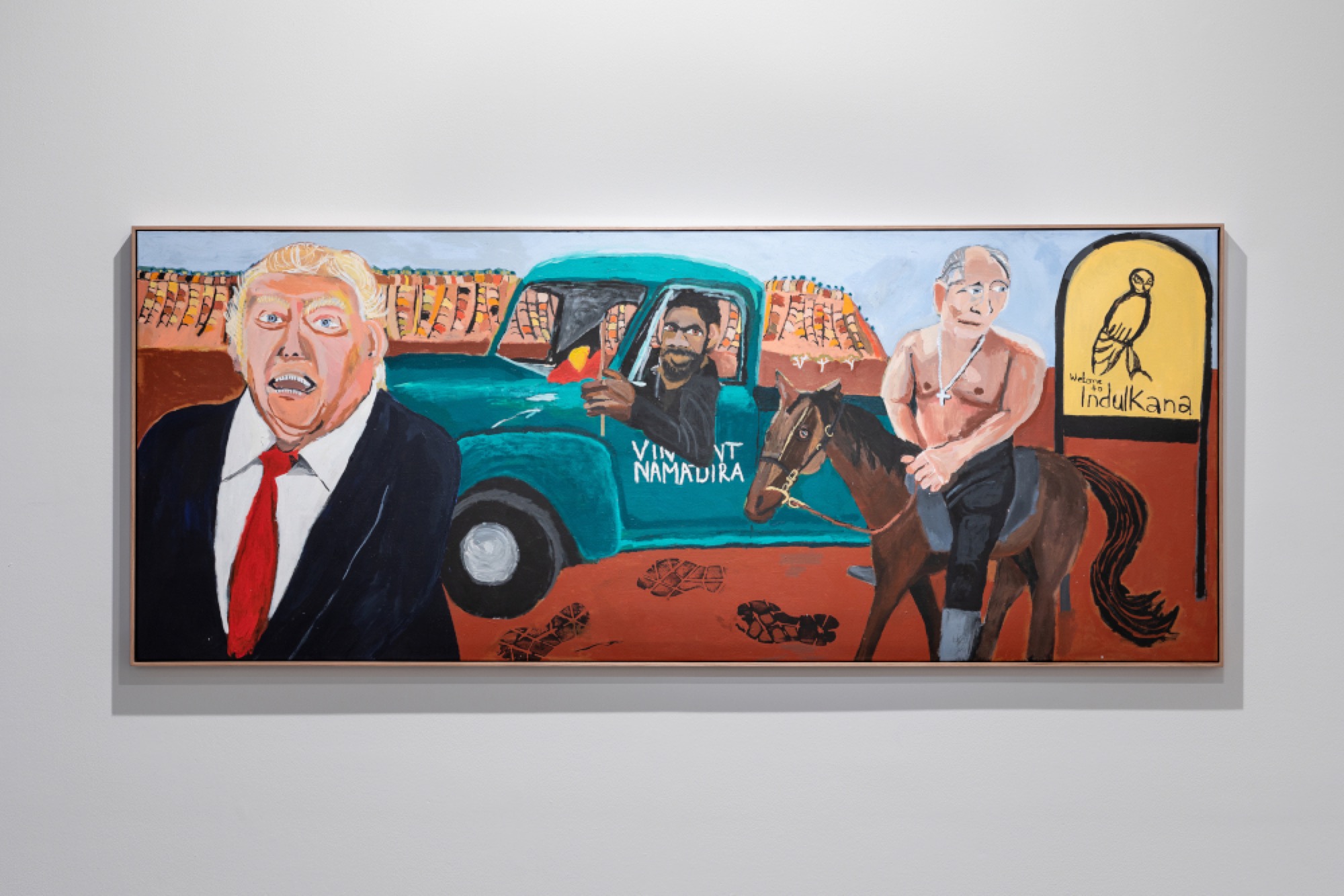 Vincent Namatjira, <em>Welcome to Indulkana</em> 2018, synthetic polymer paint on linen, 122.0 x 304.0 cm, installation view, Australian Centre for Contemporary Art, Melbourne. Courtesy the artist, Iwantja Arts, Indulkana and This is No Fantasy + Dianne Tanzer Gallery, Melbourne. Photograph: Andrew Curtis.