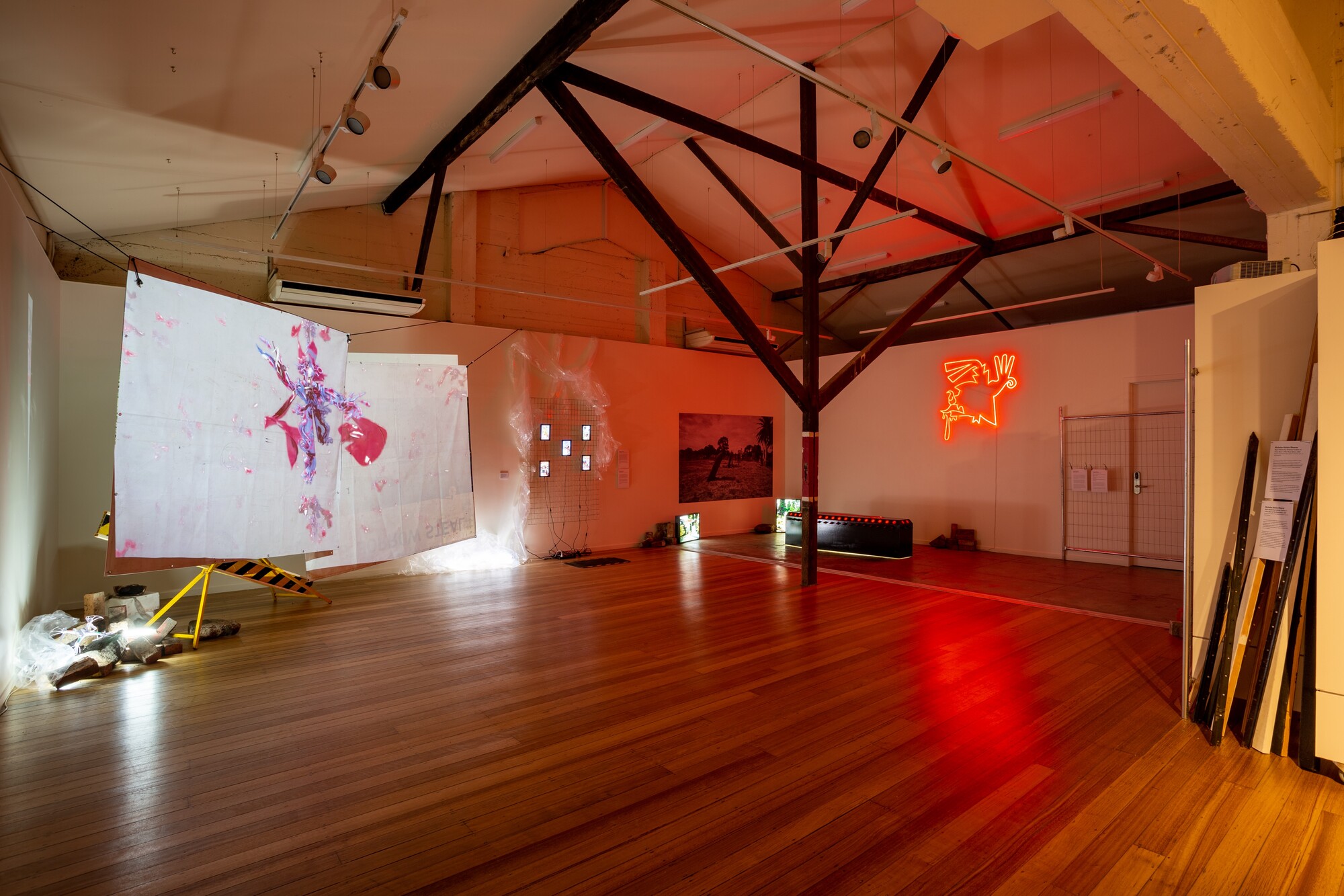 Installation view of <em>Aeon Resurrection</em>, 2022. Huntrezz Janos, <em>video,</em> 2022. 3D video animation; Huntrezz Janos, <em>face filters</em>, 2022. Virtual and augmented reality face filters; Diego Ramirez, <em>Eternal Arrival,</em> 2019. Coffin-shaped lightbox; Diego Ramirez, <em>The Infinity of The Past</em>, 2019. Neon; Diego Ramirez, <em>i want 2 die in mexican soil, so please don’t kill me yet,</em> 2022. Wallpaper; Diego Ramirez, <em>when you arrive i am the cat that loves a dog</em>, 2022. Duratran in lightbox; Diego Ramirez, <em>when you leave i am the dog that loves a cat</em>, 2022. Duratran in lightbox. Courtesy the gallery. Photo: Lucy Foster