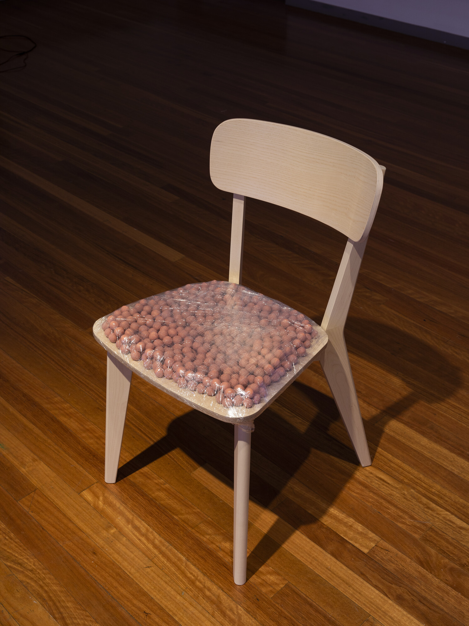 Sam Petersen, <em>Just Sit</em>, 2022. Plasticine, plastic and chair. Image courtesy of RMIT Gallery. Photo: Tobias Titz