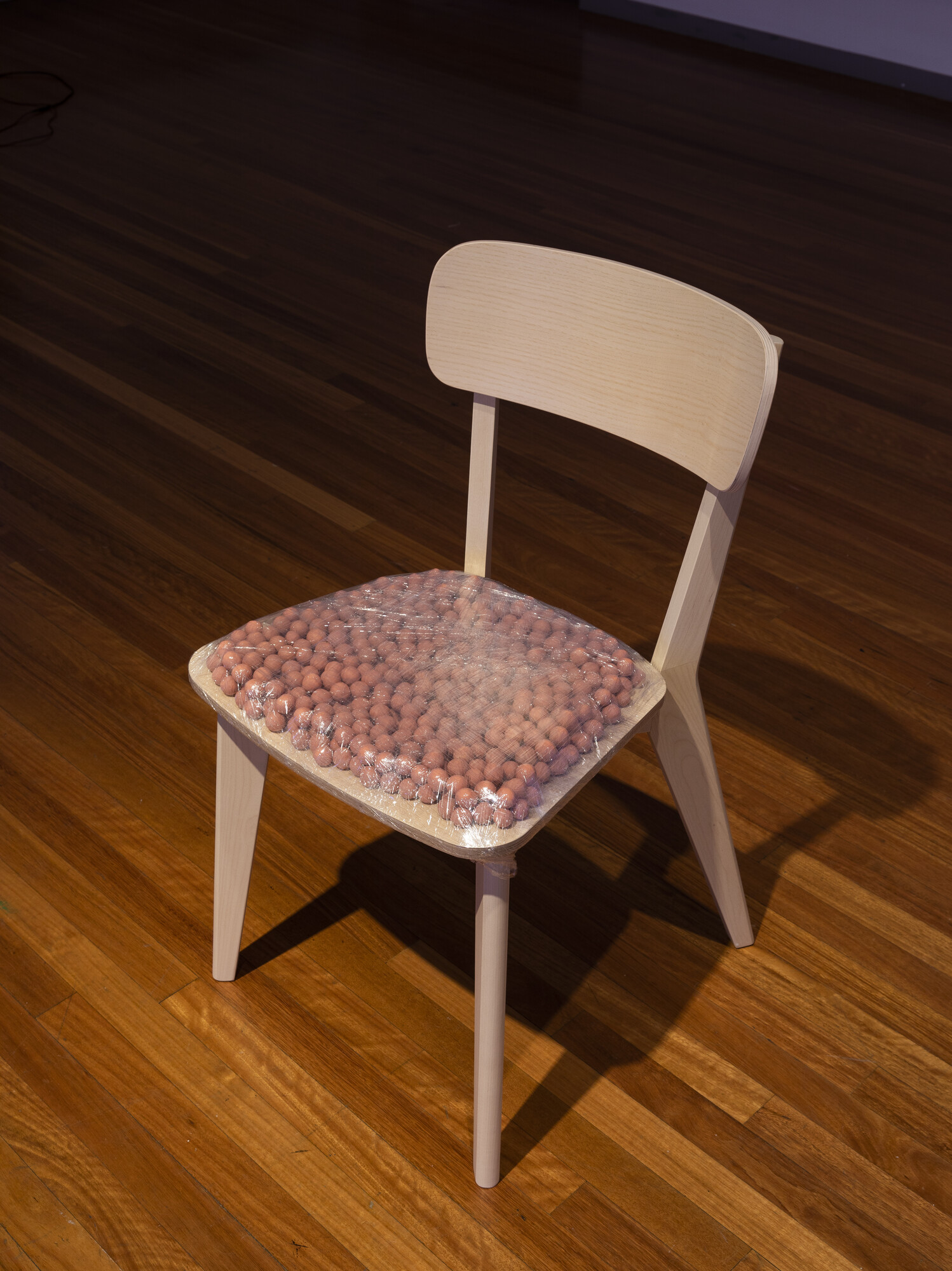 Sam Petersen, <em>Just Sit</em>, 2022. Plasticine, plastic and chair. Image courtesy of RMIT Gallery. Photo: Tobias Titz