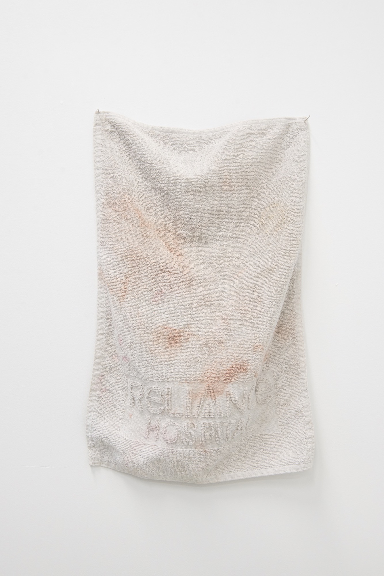 Alex Cuffe, <em>When the anaesthetic wore off the lights were so bright… the only thing they could offer was this wash cloth… I woke up screaming… all they could offer was this wash cloth… the first words I remember were addressed to a body of a different gender… I held the nurses hand smiling while my first words were to correct her… and all I have left is a wash cloth that will never be clean​</em>, cotton cloth, hair dye, 2019.