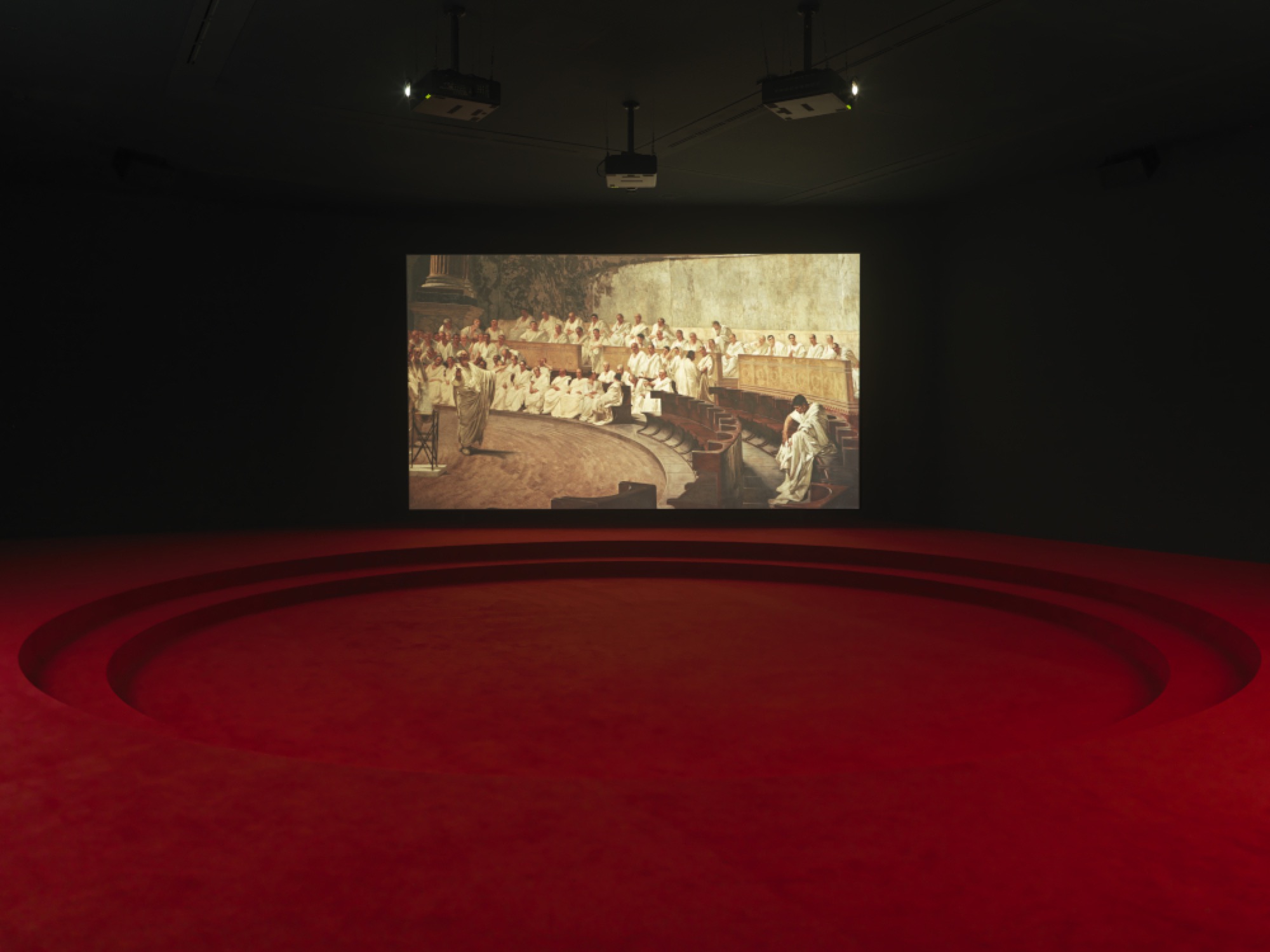 Angelica Mesiti, <em>ASSEMBLY</em>, 2019 (installation shot) three-channel video installation in architectural amphitheater. HD video projections, color, six-channel mono sound, 25 mins, dimensions variable. © Photography: Josh Raymond. Commissioned by the Australia Council for the Arts on the occasion of the 58th International Art Exhibition–La Biennale di Venezia. Courtesy of the artist and Anna Schwartz Gallery, Australia and Galerie Allen, Paris.
