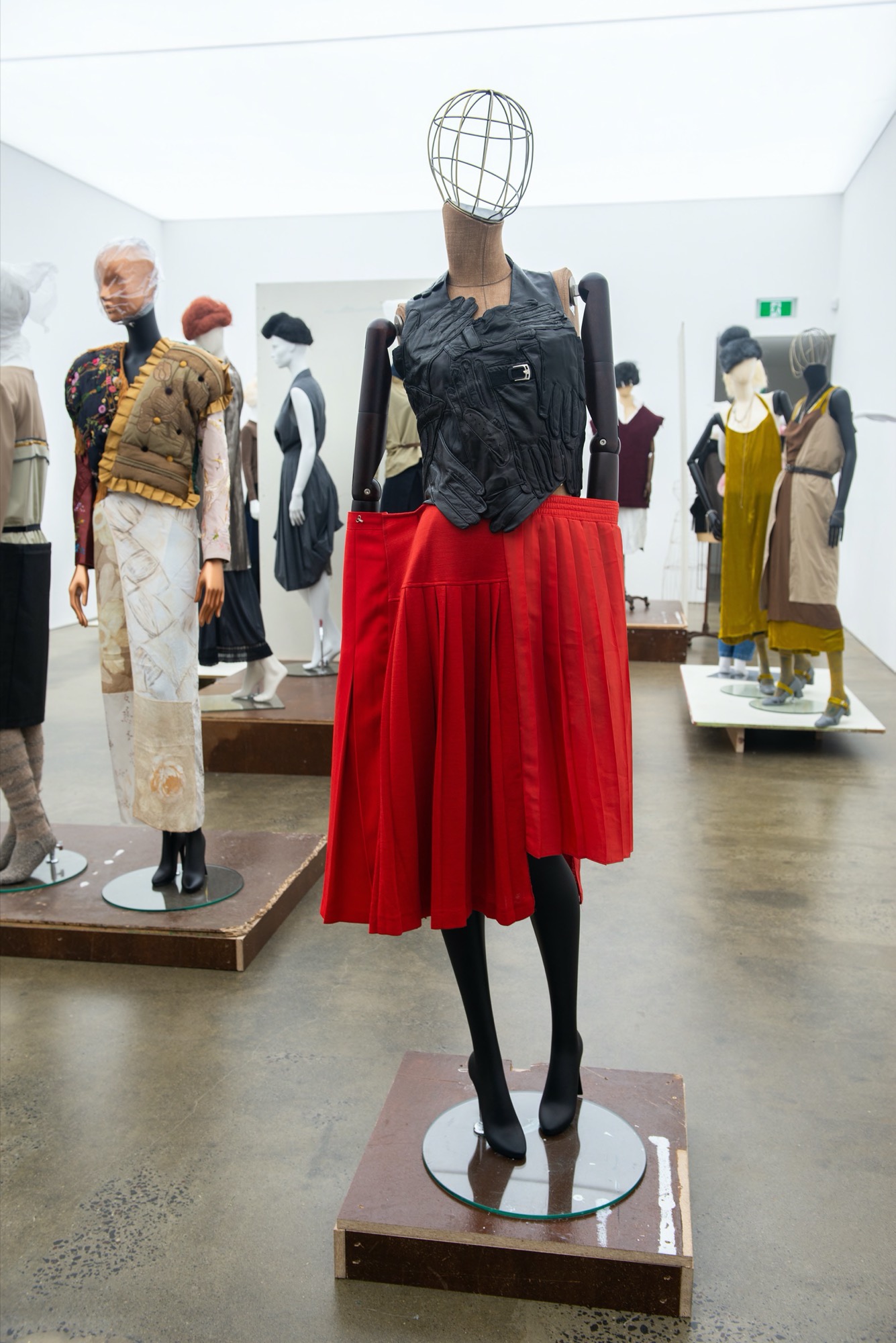 Martin Margiela, SS 200, Backless corsage made from assembled vintage black leather gloves. Martin Margiela, Artisanal, SS 2001 Pleated red jersey and polyester skirt made of assembled vintage skirts. Photo: Agnieszka Chabros