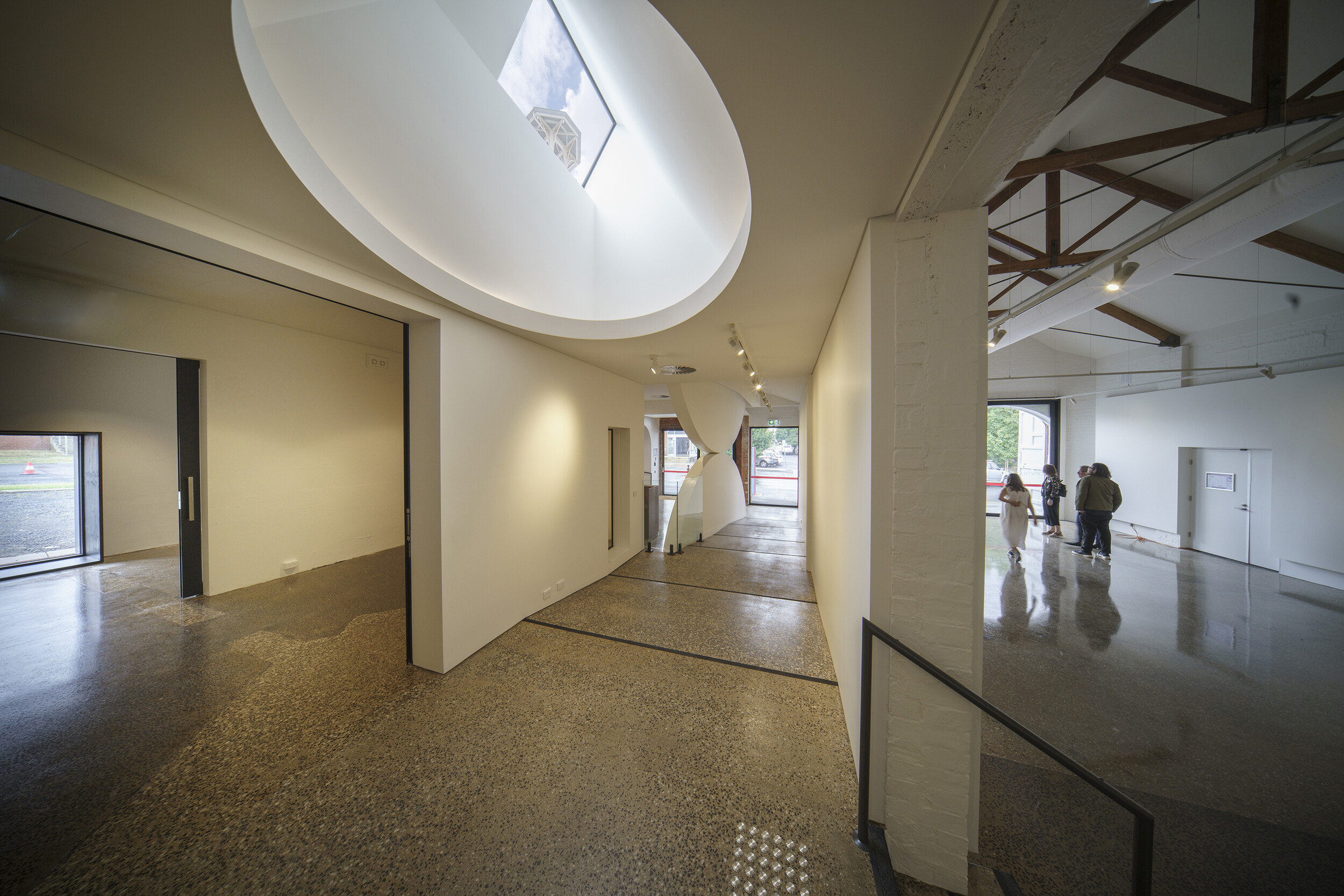<p>Looking back at the entry at the bottom of the ramp: the staff office and art store are to the left, the main gallery space to the right, and a second skylight directs light toward the tower. Photograph by John Gollings.</p>