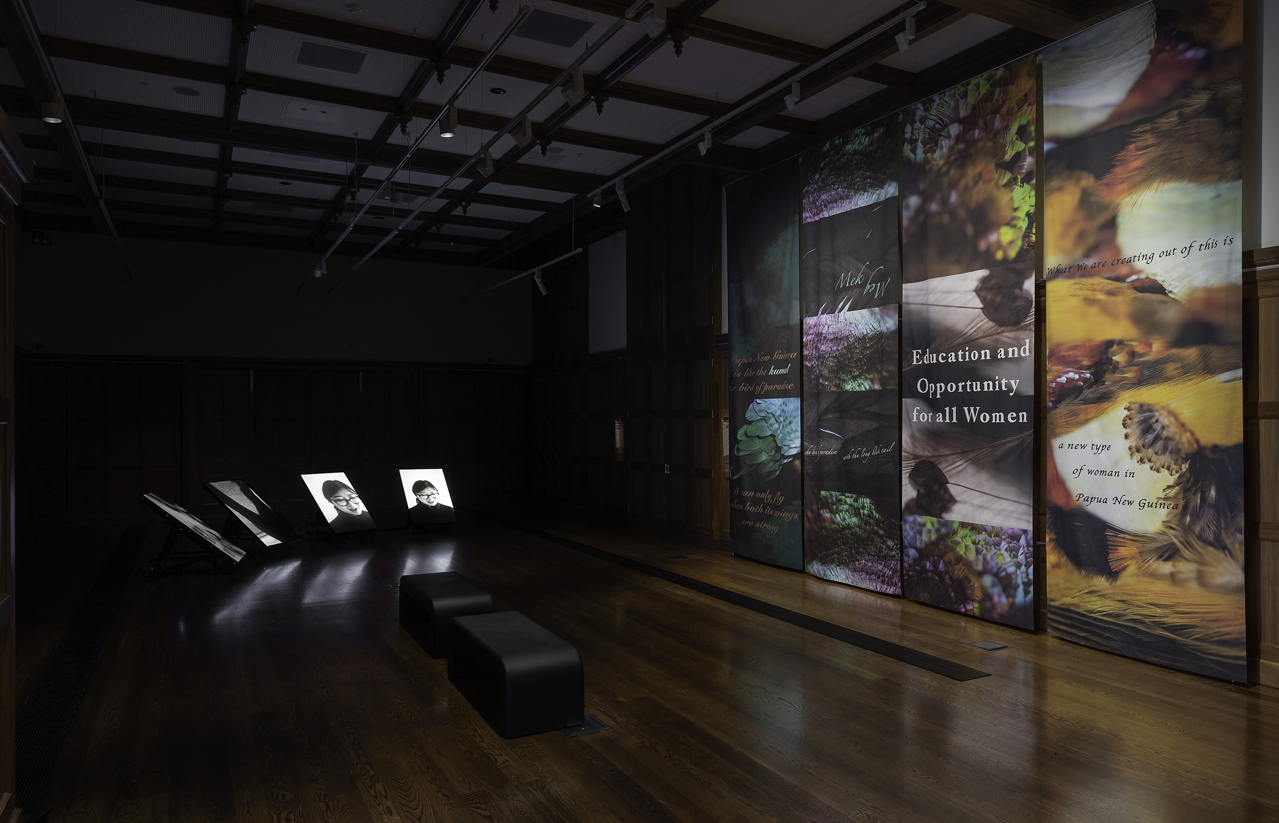 Installation view of James Nguyen, An Australian National Song 2022, 4-channel video, 8:55 min and Lisa Hilli, Birds of a Feather 2022, digital print on fabric. On display in Collective Unease at the Ian Potter Museum of Art, Old Quadrangle, University of Melbourne. Photo: Christian Capurro. Courtesy of the curators.