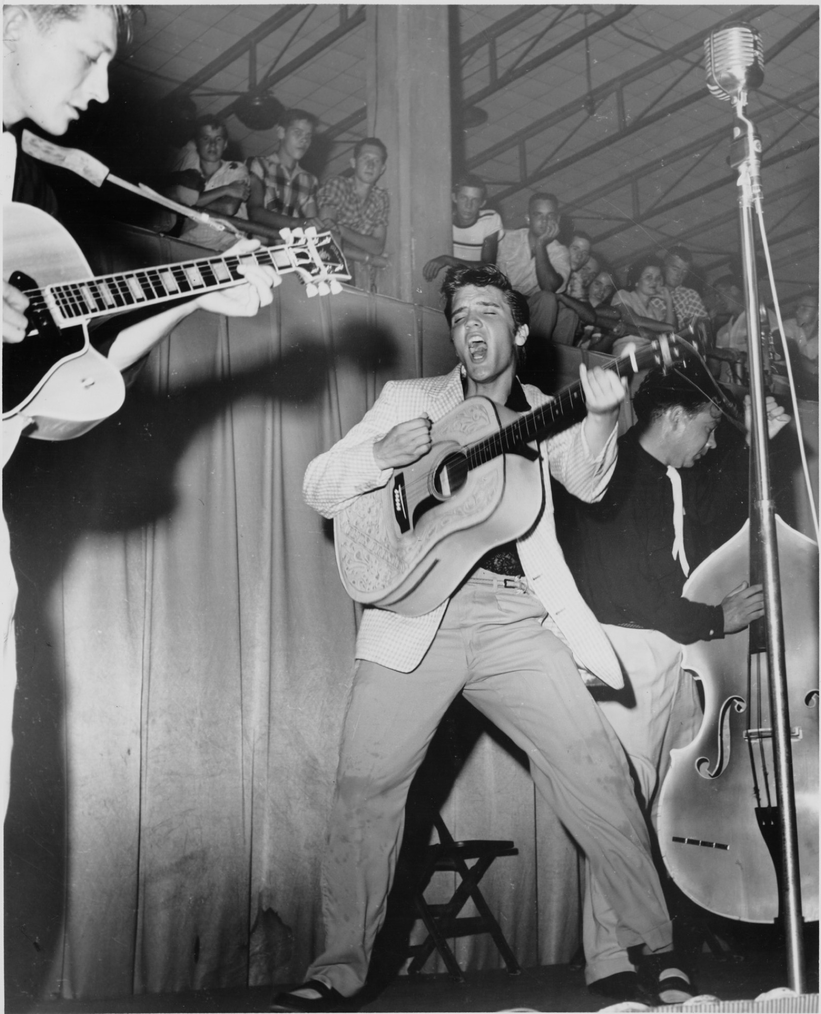 Elvis on stage in Tampa, Florida in 1955, captured in an image that would be used for the cover of his first album. © EPE. Graceland and its marks are trademarks of EPE. All Rights Reserved. Elvis Presley™ © 2022 ABG EPE IP LLC.