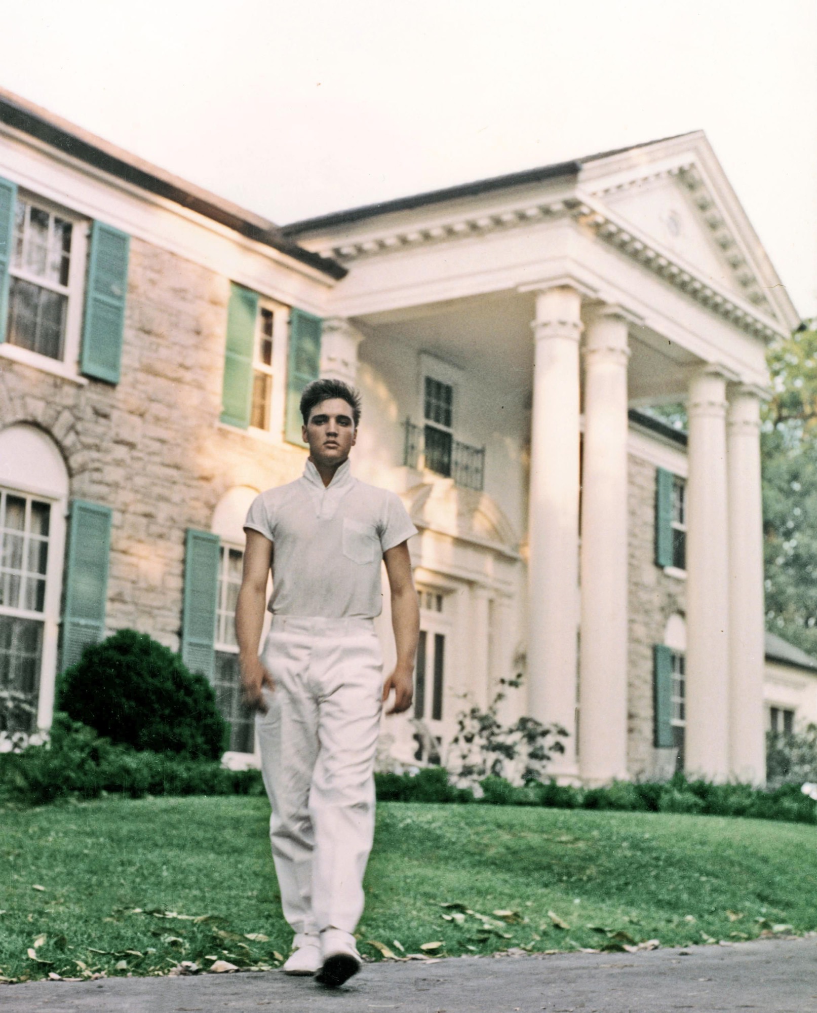 Elvis Presley strolls the grounds of his Graceland estate, 1957. Photo by Michael Ochs/Getty Images. © EPE. Graceland and its marks are trademarks of EPE. All Rights Reserved. Elvis Presley™ © 2022 ABG EPE IP LLC.