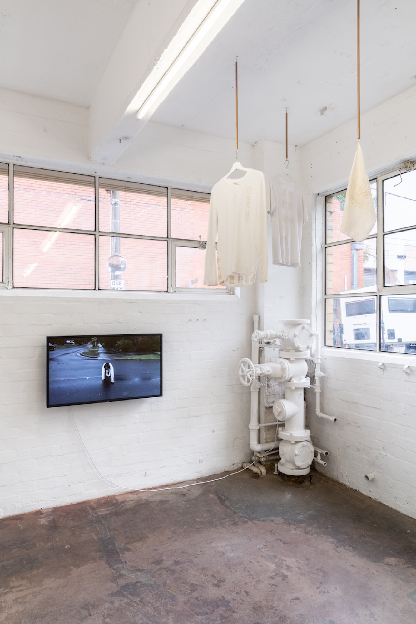 <em>I will never run out of lies or love</em> installation view, image courtesy of gallery, photo: Christo Crocker. Above: Anjie Pai, <em>Ah gong&#39;s top, Ah gong&#39;s undershirt</em> and <em>Ah gong&#39;s handkerchief,</em> 2018-2019, raw silk on cotton and linen, dimensions variable. Below: <em>On Steady Ground,</em> 2019, digital video footage (looped) 13:00 mins.