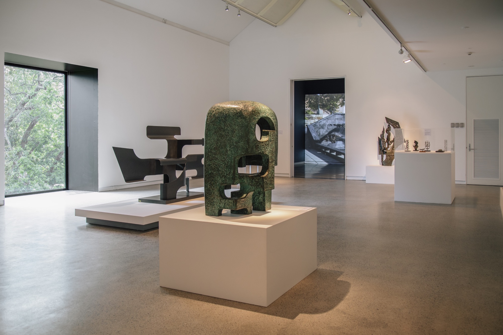 Installation view, Margel Hinder: Modern in Motion, Heide Museum of Modern Art, with Hinder’s <em>Green Garden Sculpture</em> (1972) and <em>Black Silhouette</em> (1979), and beyond, in the far room, Andrew Yip’s <em>Margel Hinder Immersive II (Civic Park)</em> (2020).