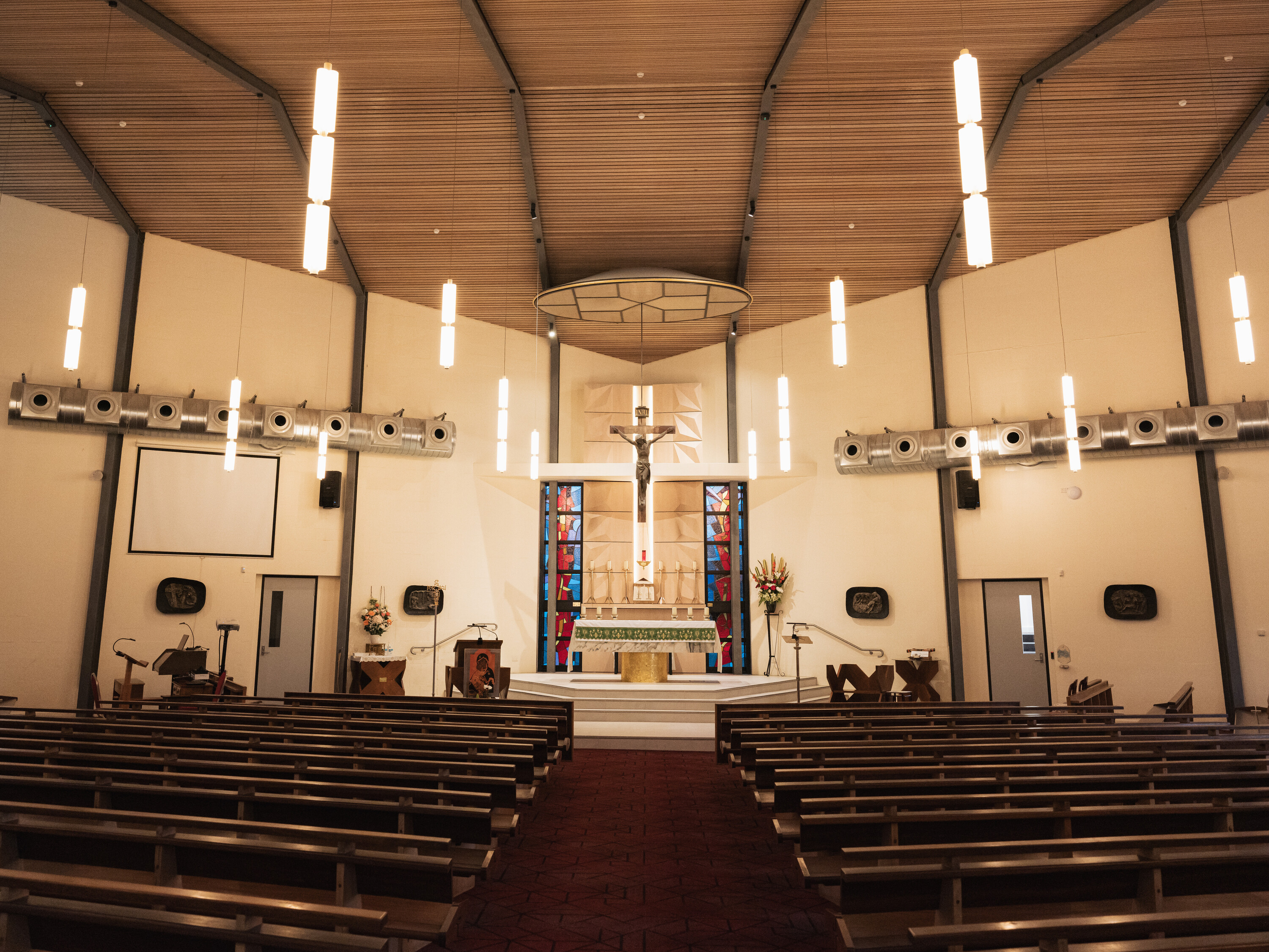 <p>The original geometric sanctuary screen has been removed post-renovation and heating ventilation has been added. Most original elements, including the bronze reliefs and stained glass behind the church altar, remain. Photograph by Caitlin Wong.</p>