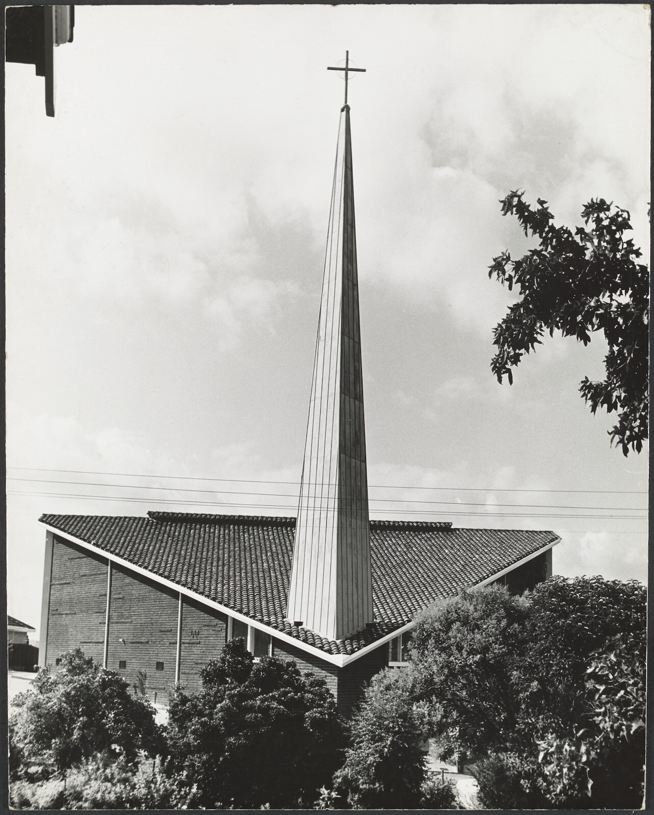 <p>The iconic spire pierces through the roofline of the Mary Immaculate Church. Date and photographer unknown. Photograph courtesy of <a href=