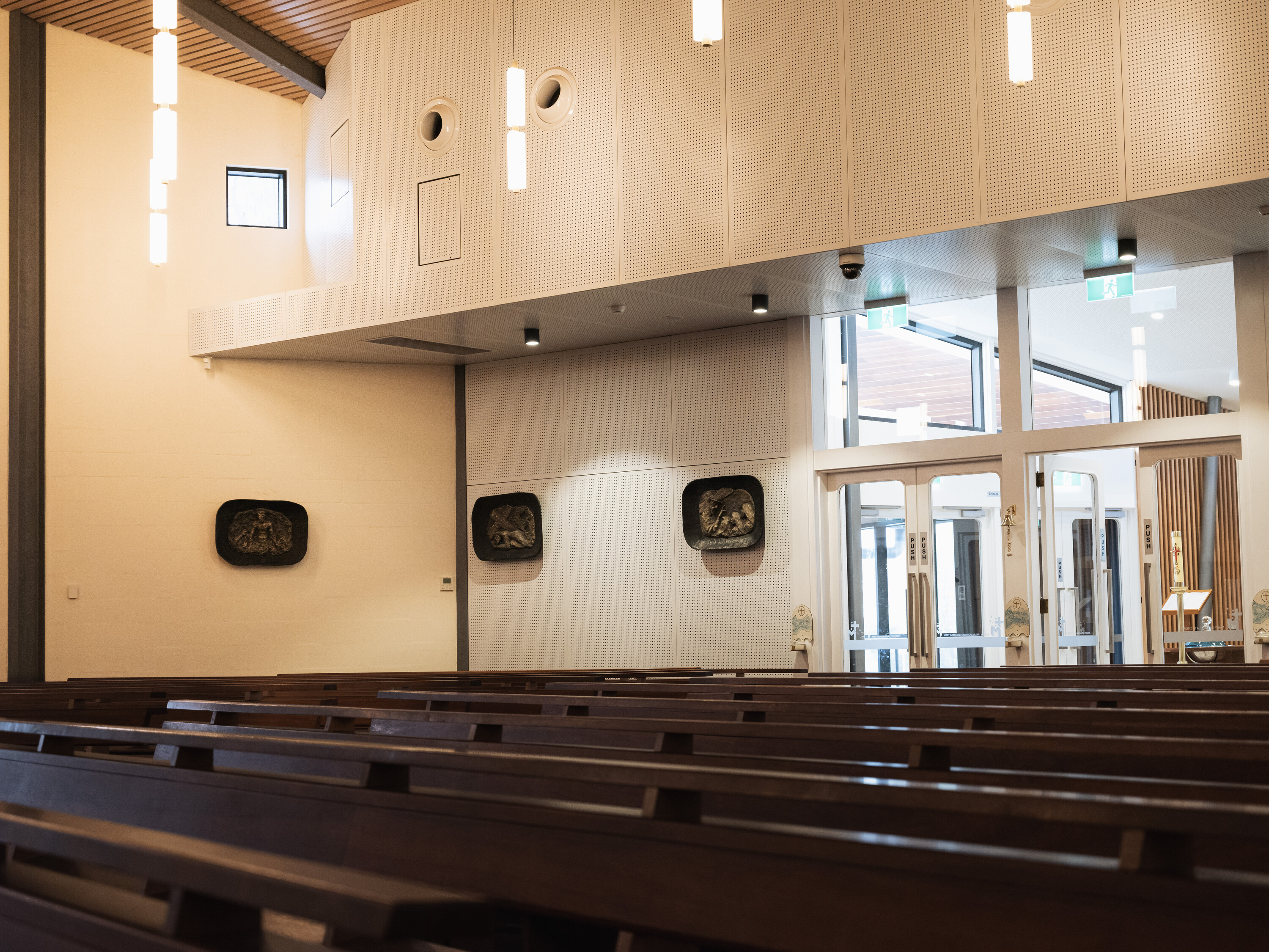 <p>Interior photograph taken in 2024 within the modified 1960 interior showing the 2023 modifications and the bronze reliefs by Matcham Skipper from the 1960 version. Photograph by Caitlin Wong.</p>