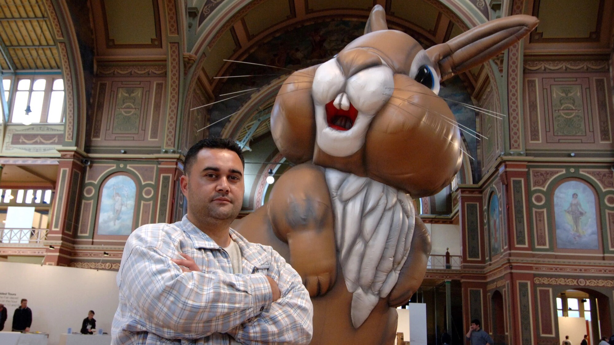 <p>New Zealand artist Michael Parekōwhai in front of his giant rabbit sculpture <em>Cosmo</em> at Melbourne’s Royal Exhibition Building in 2006. Photo: AAP</p>