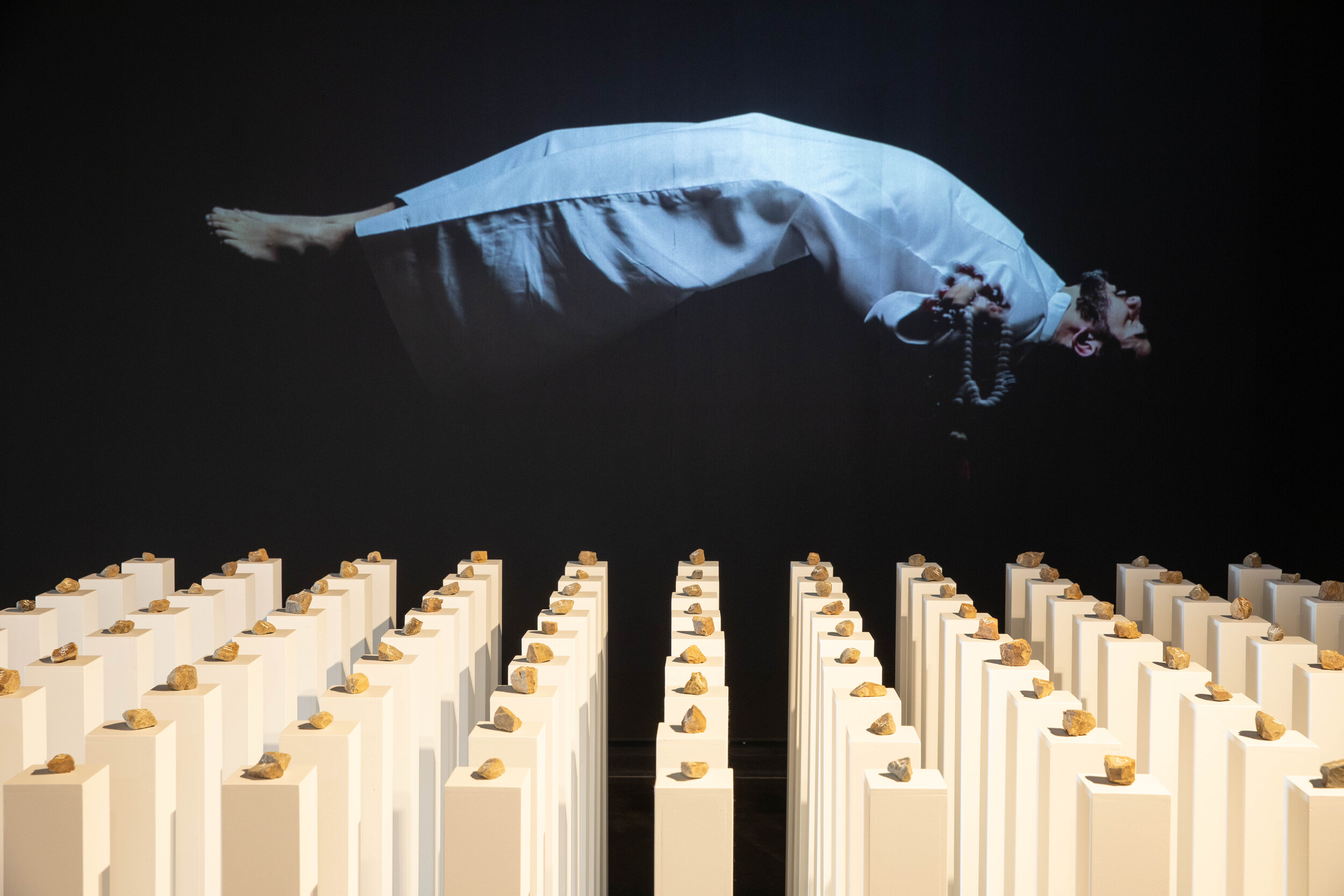 <p>Installation view, Ayman Kaake, <em>Stones Will Remain Stones</em>, 2025, mixed media installation, 230 x 285 x 100 cm (foreground) and <em>See</em>, 2025,<em> </em>single channel video, 6 minutes 47 seconds (background). Photo: Simon Aubor</p>