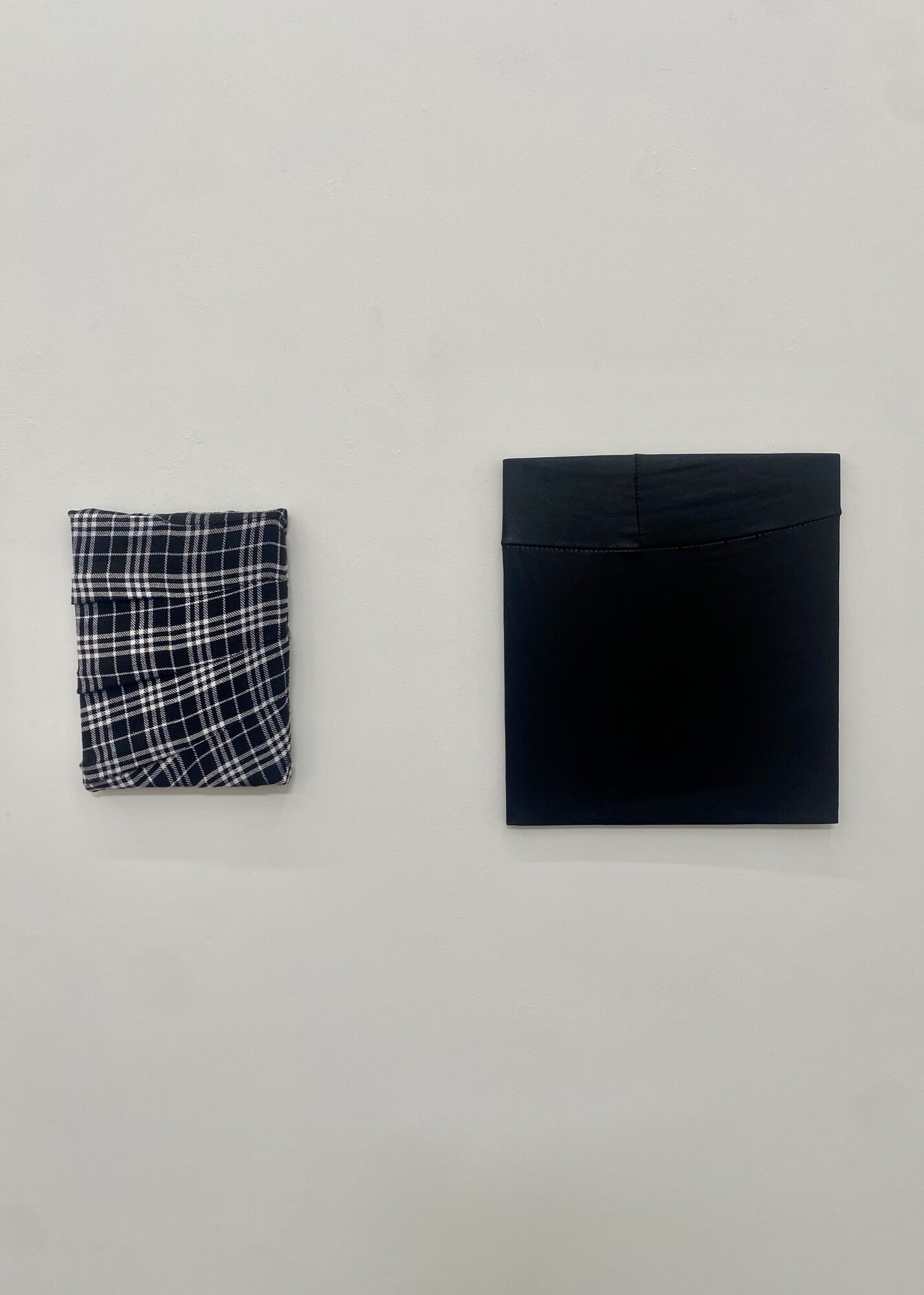 Isabella Darcy, <em>Untitled (black and white tartan wrap)</em>, 2022.Black and white tartan skirt over canvas. Conners Conners Gallery; <em>pleather pull</em>, 2019. Pleather leggings over woodboard. Conners Conners Gallery.