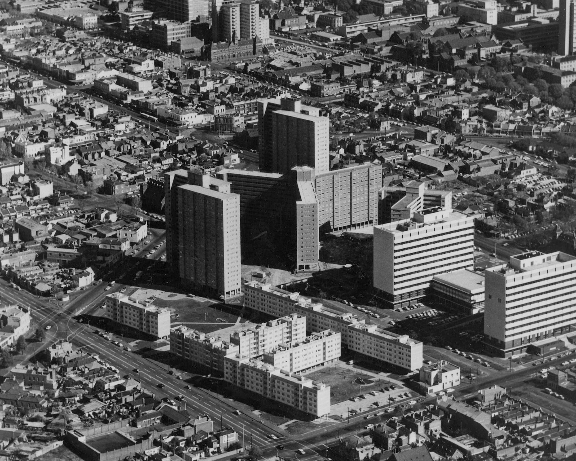 <p>An oblique aerial view of Carlton captures how the public housing towers challenged the pre-existing streetscapes. Date unknown, presumably 1960s. Photograph by Colin Sach, courtesy of the University of Melbourne Archives.</p>