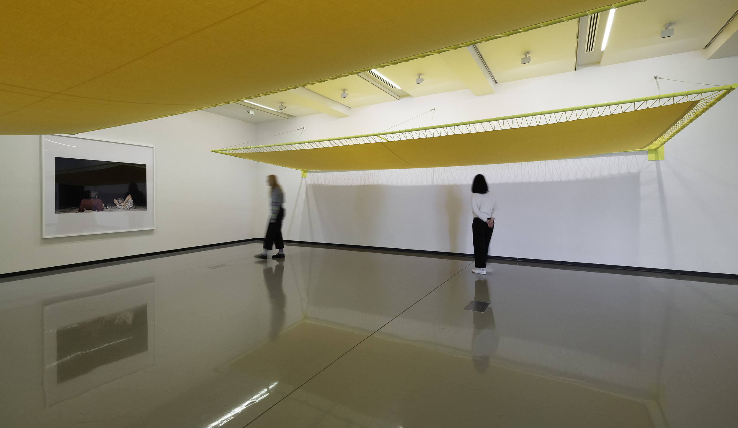 Paul Knight, <em>Don’t stand by my side, stand inside</em>, 2023, handwoven cotton bedsheets, cotton cord, aluminium, stainless steel cable and painted steel. Courtesy of the artist and Neon Parc, Naarm/Melbourne. <em>Untitled</em> photograph from the series <em>Chamber Music</em>, 2009–. Monash University Collection, Naarm/Melbourne. Installation view, Paul Knight: L’ombre de ton ombre, Monash University Museum of Art, Naarm/Melbourne, 2023. Photo: Christian Capurro