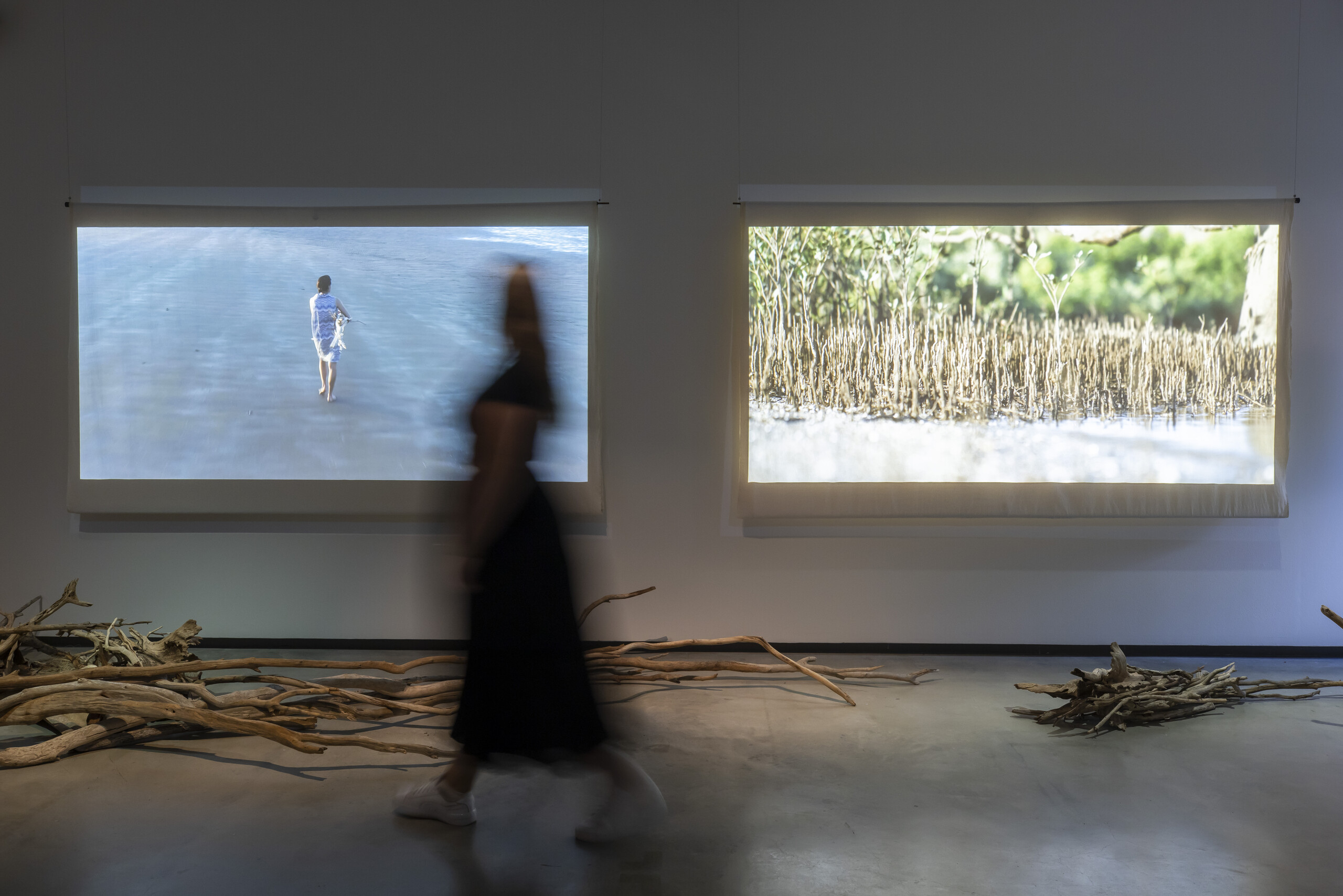 Katie West, <em>I love you my baby, you are my first born</em>, 2020-22, installation view, Primavera 2022: Young Australian Artists, Museum of Contemporary Art Australia, Sydney, 2022, found driftwood and metal, 2-channel video projection, image courtesy the artist and Museum of Contemporary Art Australia, © the artist, photograph: Anna Kučera