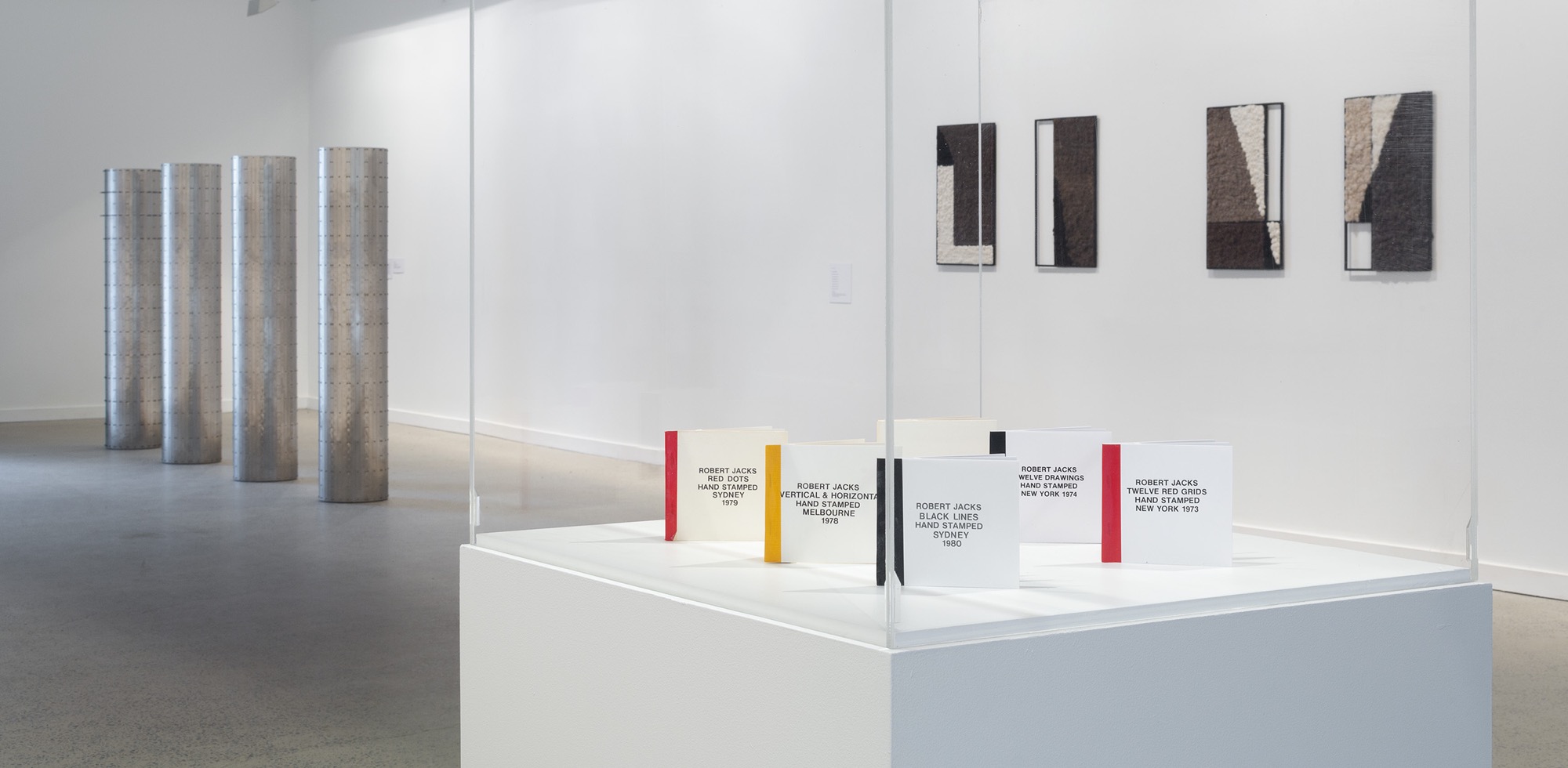 <em>Serial</em>, installation view, McClelland Sculpture Park + Gallery, Langwarrin, 2019. Robert Jacks, <em>Twelve red grids, hand stamped</em>, New York 1973; <em>Twelve drawings, hand stamped</em>, New York 1974; <em>Color book, hand stamped</em>, New York 1975; <em>Vertical & horizontal, hand stamped</em>, Melbourne 1978; <em>Red dots, hand stamped</em>, Sydney 1979; <em>Black lines, hand stamped</em>, Sydney 1980, Adrian Page, <em>Four Columns</em> 2008, Sanné Mestrom, <em>Black paintings</em> 2014. Photo: Christian Capurro.