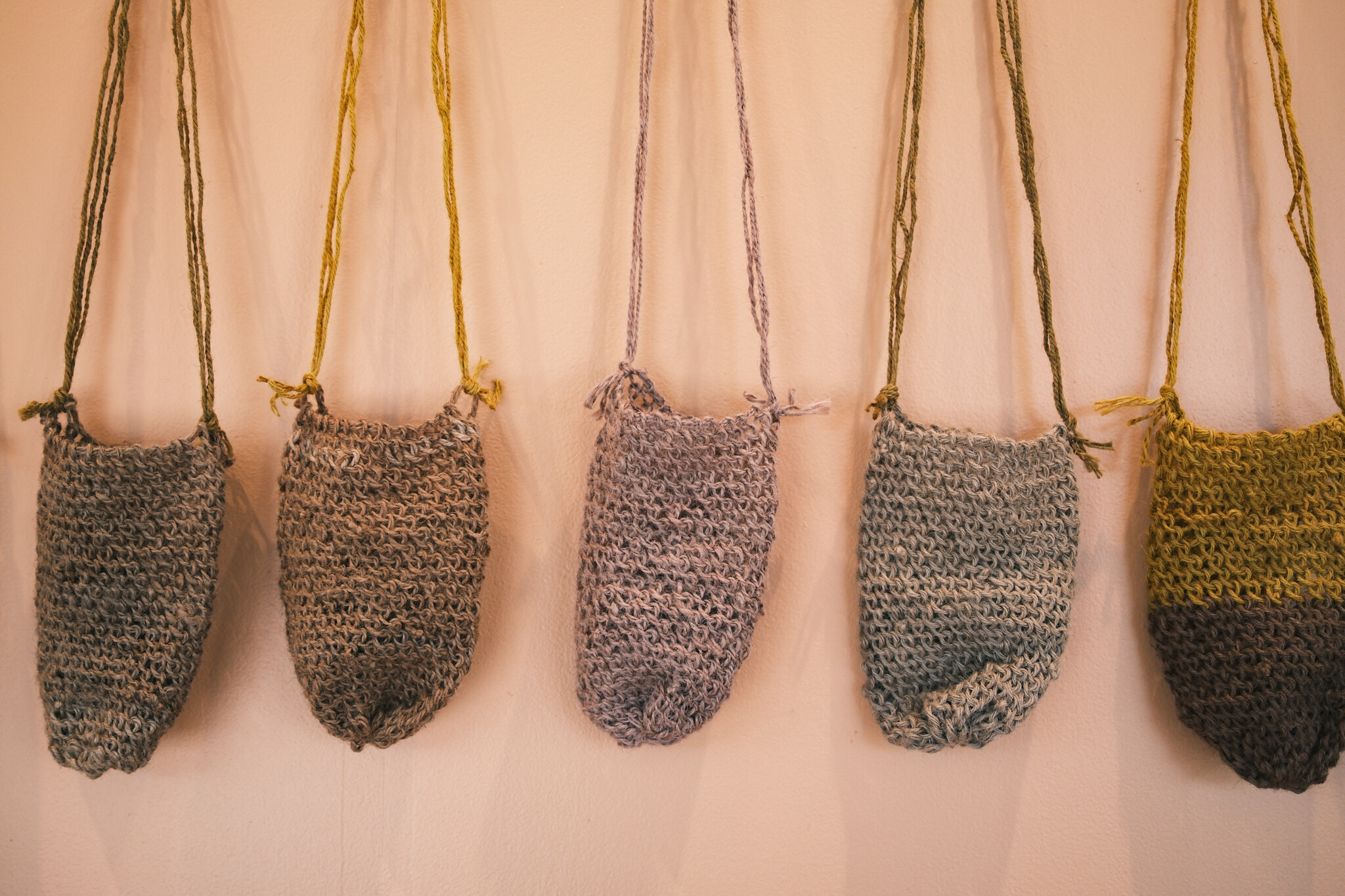 <p>Jessika Spencer, from left: <em>Stringybark and Coffee Handle</em>, 2024, woven dilly bag, 66 x 15 x 6 cm; <em>Eucalyptus Leaves and Turmeric</em>, 2024, woven dilly bag, 80 x 16 x 6 cm; <em>Beetroot</em>, 2024, woven dilly bag, 87 x 15 x 6 cm; <em>Coffee Handle and Decaf Base</em>, 2024, woven dilly bag, 80 x 15 x 6 cm; <em>Red Onion and Turmeric</em>, 2024, woven dilly bag, 70 x 15 x 6 cm. Photo: Tom Hvala</p>