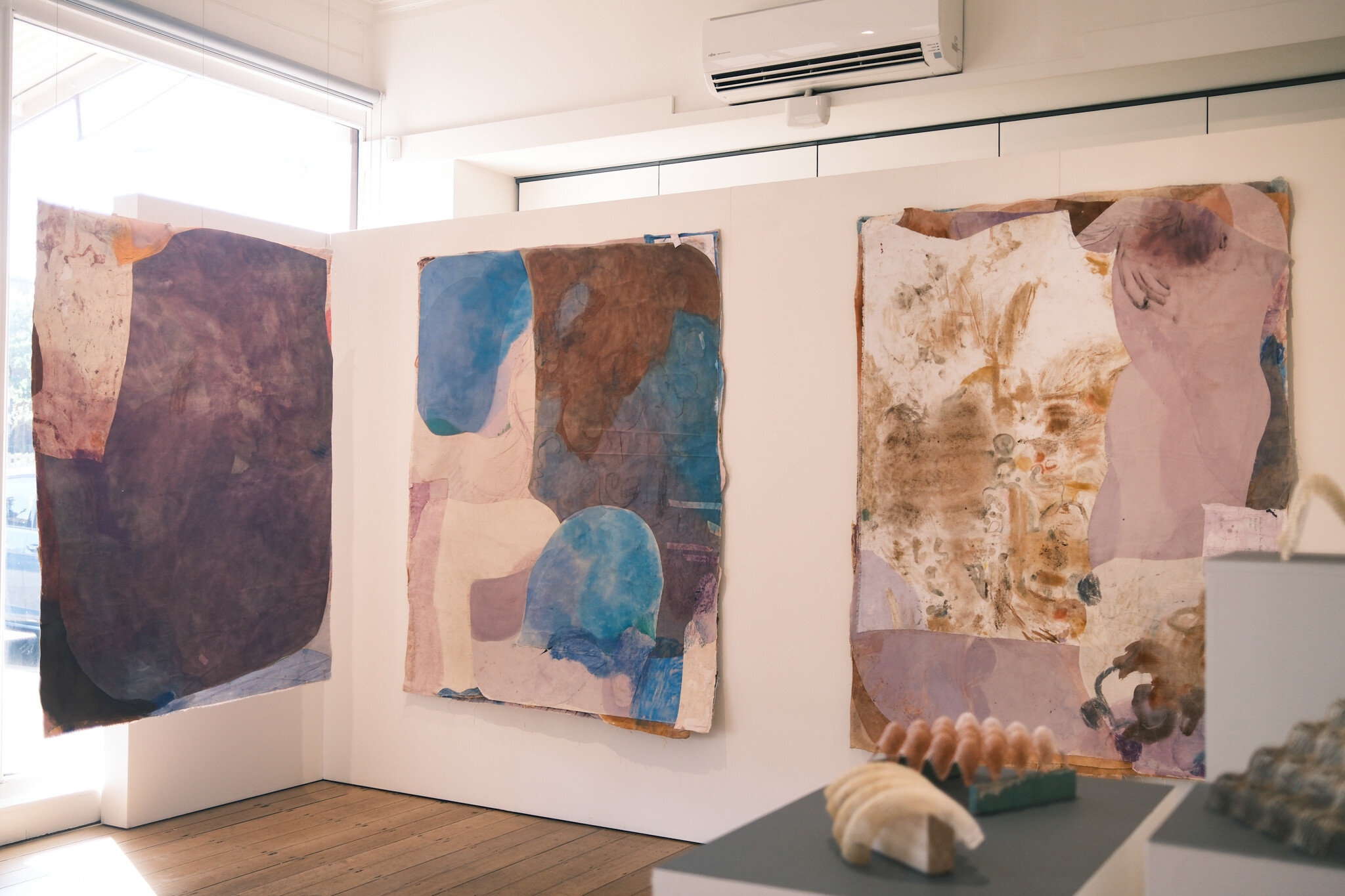 <p>Jahnne Pasco-White, from left: <em>Kinning with Lake 3</em>, 2024, lavender, plant-based crayons, oil pastel, watercolour, oil paint, raw pigment, dye, tempura, acrylic, silk, linen, cotton on canvas, 171 x 130 cm; <em>Kinning with Lake 8</em>, 2024, lavender, plant-based crayons, oil pastel, watercolour, reclaimed oil paint, raw pigment, indigo dye, tempura, natural dyes, acrylic, paper, pen, silk, linen, cotton on canvas, 183x 148 cm; <em>Kinning with Lake 1</em>, 2024, lavender, broad bean, spirulina, plant-based crayons, turmeric, oil pastel, reclaimed oil paint, coffee, tea leaves, raw pigment, indigo dye, tempura, natural dyes, acrylic, rice glue, paper, pen, silk, linen, cotton on canvas, 185 x 136 cm. Photo: Tom Hvala</p>