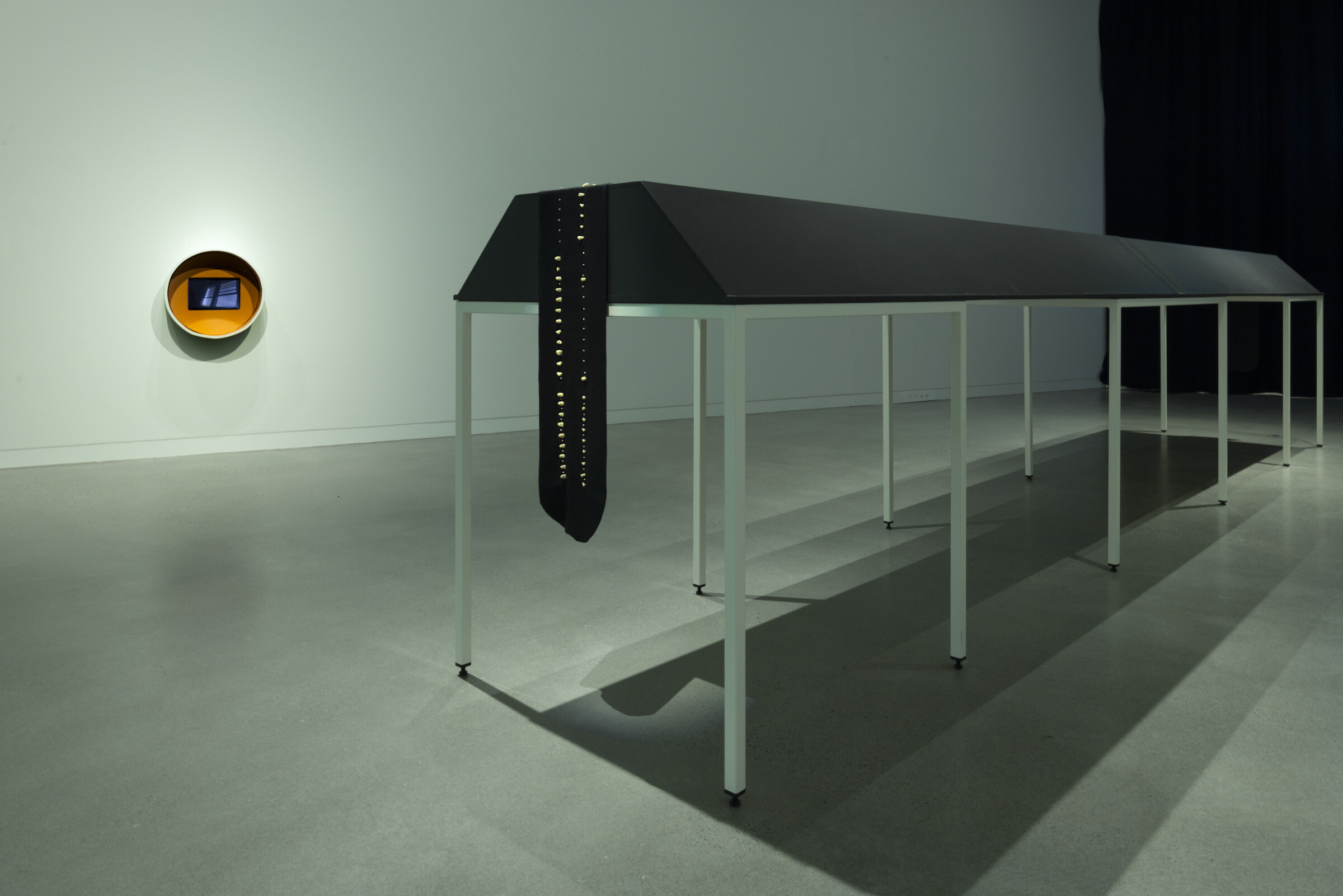 <p>Installation view of Tiyan Baker, <em>Dental camera study with Toba</em>, 2026, single channel video, 1:43 minutes (left) and Tiyan Baker, <em>To tangle together like coursing water (mnemonic device)</em>, 2026, resin cast teeth, lyocell twill, nylon thread, glass beads, vinyl stickers (right). <em>Tiyan Baker: Mouth Mnemonica</em>, 2026, Newcastle Art Gallery. Photo: Edwina Richards.</p>