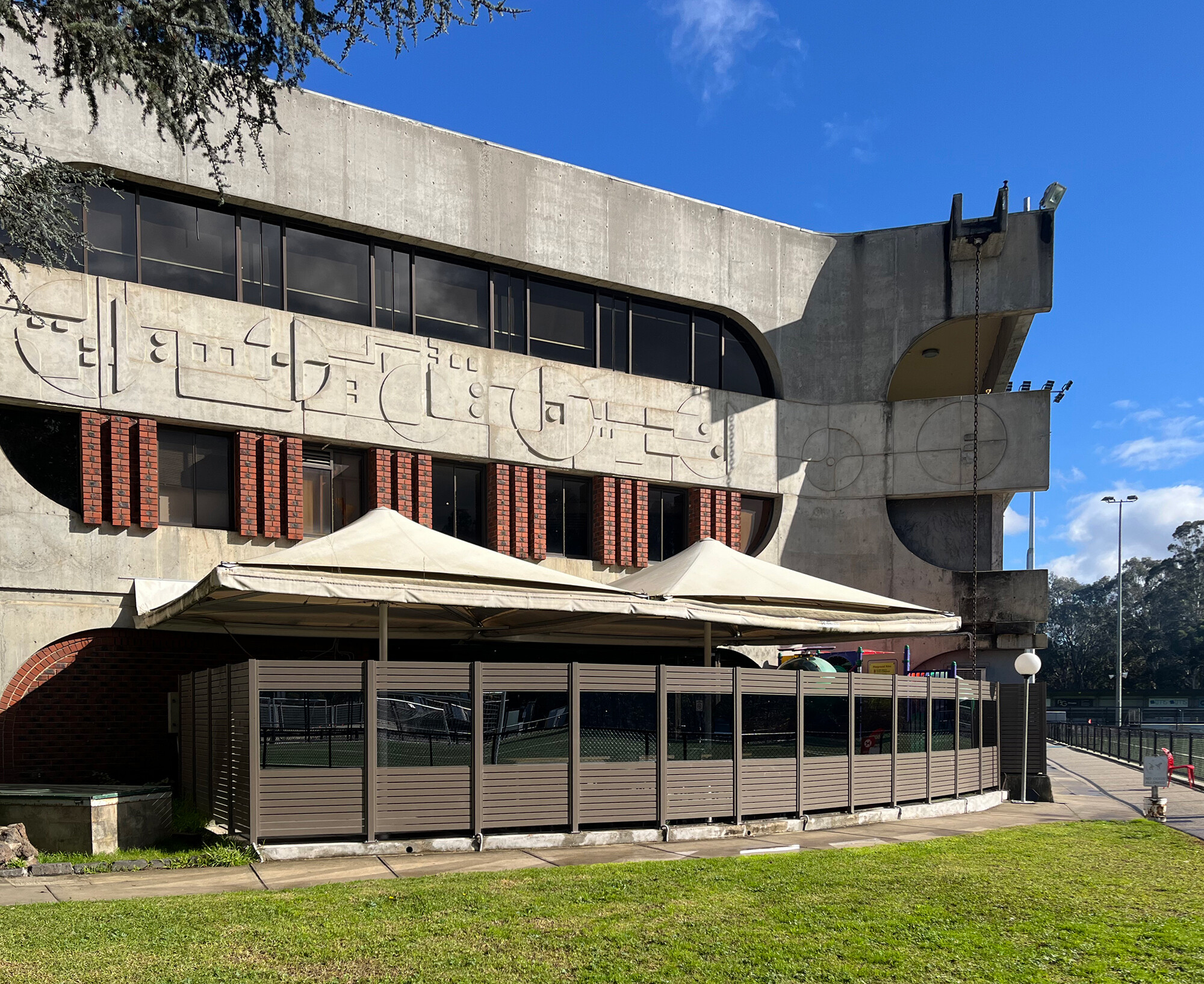 <p>Geometric relief patterns and filleted concrete as part of Smrekar’s 1972–1973 design with more recent additions in the foreground. Photograph by the author.</p>
