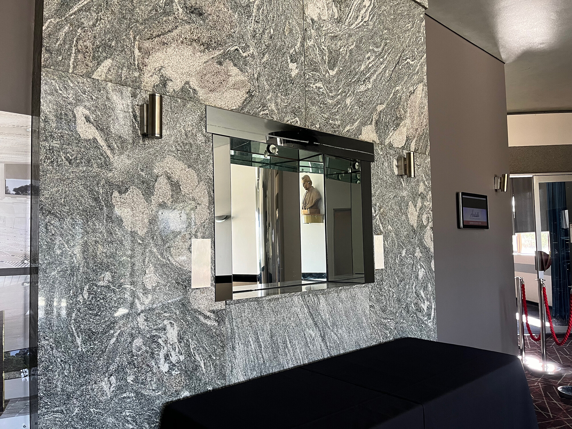 <p>Marble feature wall. In the mirror’s reflection, you can see a bronze bust of Pope Pius X. Photograph by the author.</p>