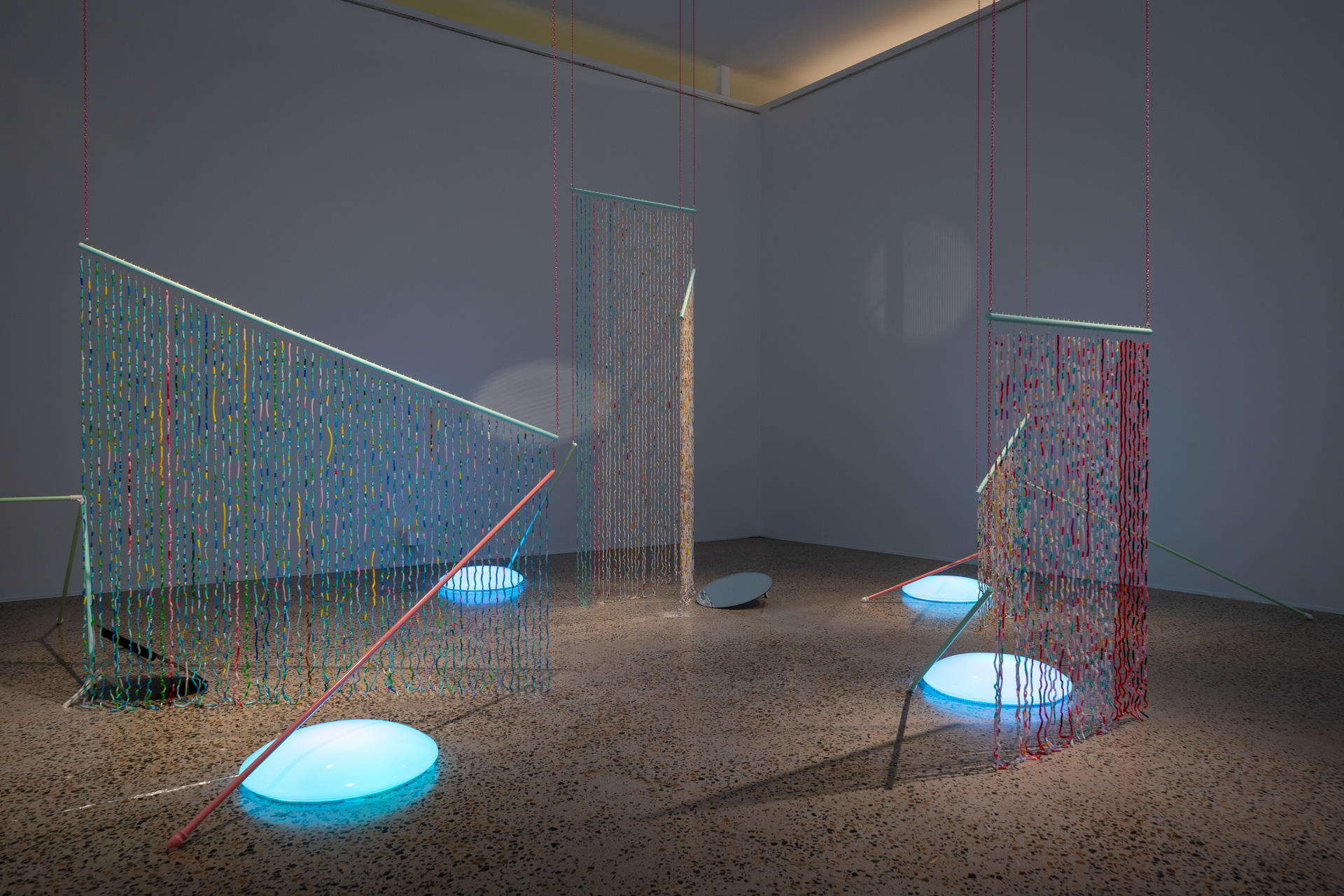 Installation view of <em>West of Central</em>, Bathurst Regional Art Gallery, 1 July–27 August 2023, featuring June Golland, <em>Past Present Continuous</em>, 2023, plastic tube beading, pink chains, wooden dowel, spray paint, dimensions variable. Courtesy the artist. Photo: David Roma Photography