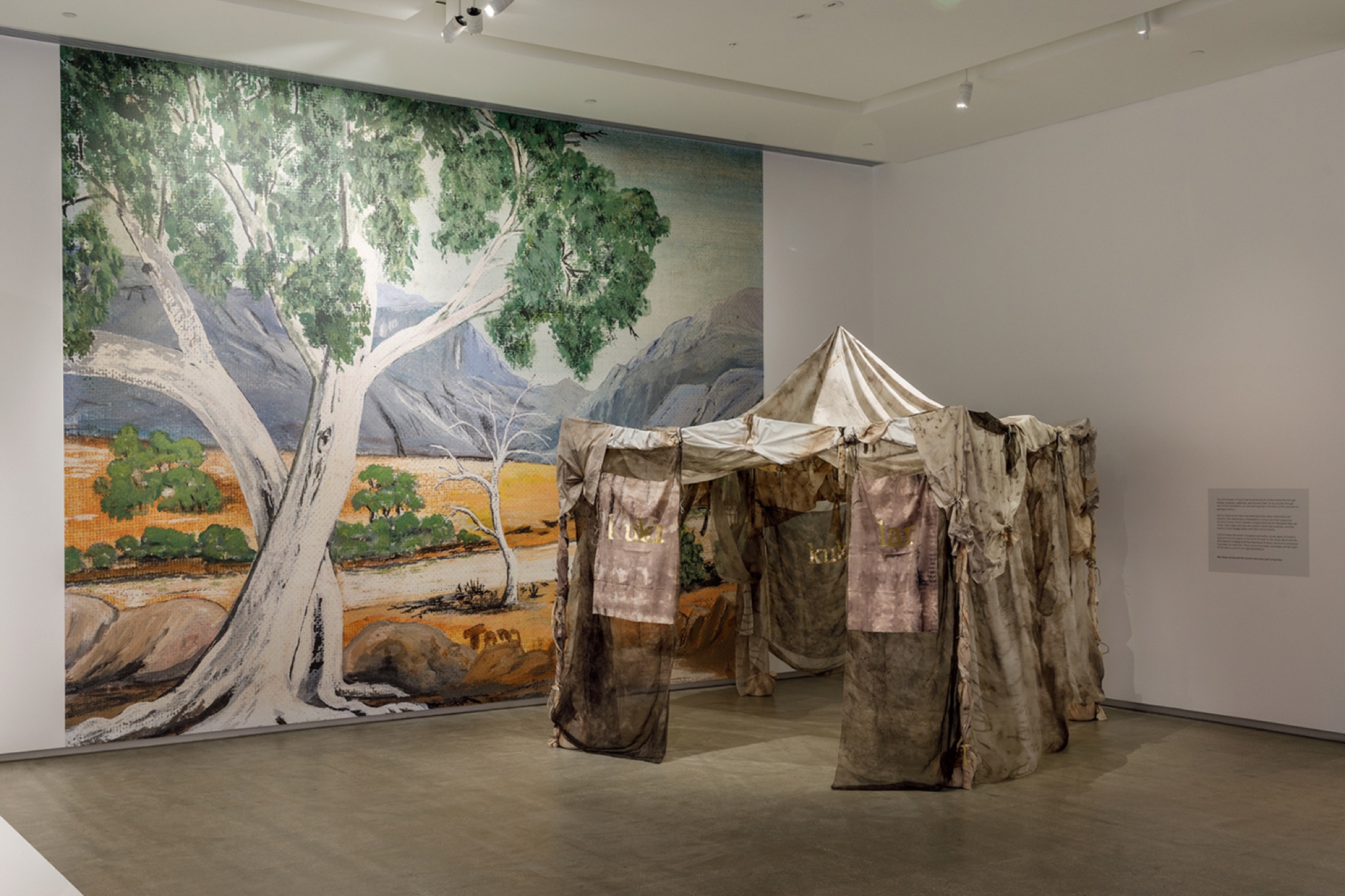 Paola Balla, <em>Murrup (Ghost) Weaving in Rosie Kuka Lar (Grandmother’s Camp)</em> 2021 with Rosie Tang, <em>Untitled Wallpaper</em>, image c. 1978, reproduced 2021, installation view, WILAM BIIK, TarraWarra Museum of Art, 2021. Courtesy of Paola Balla.Photo: Andrew Curtis.