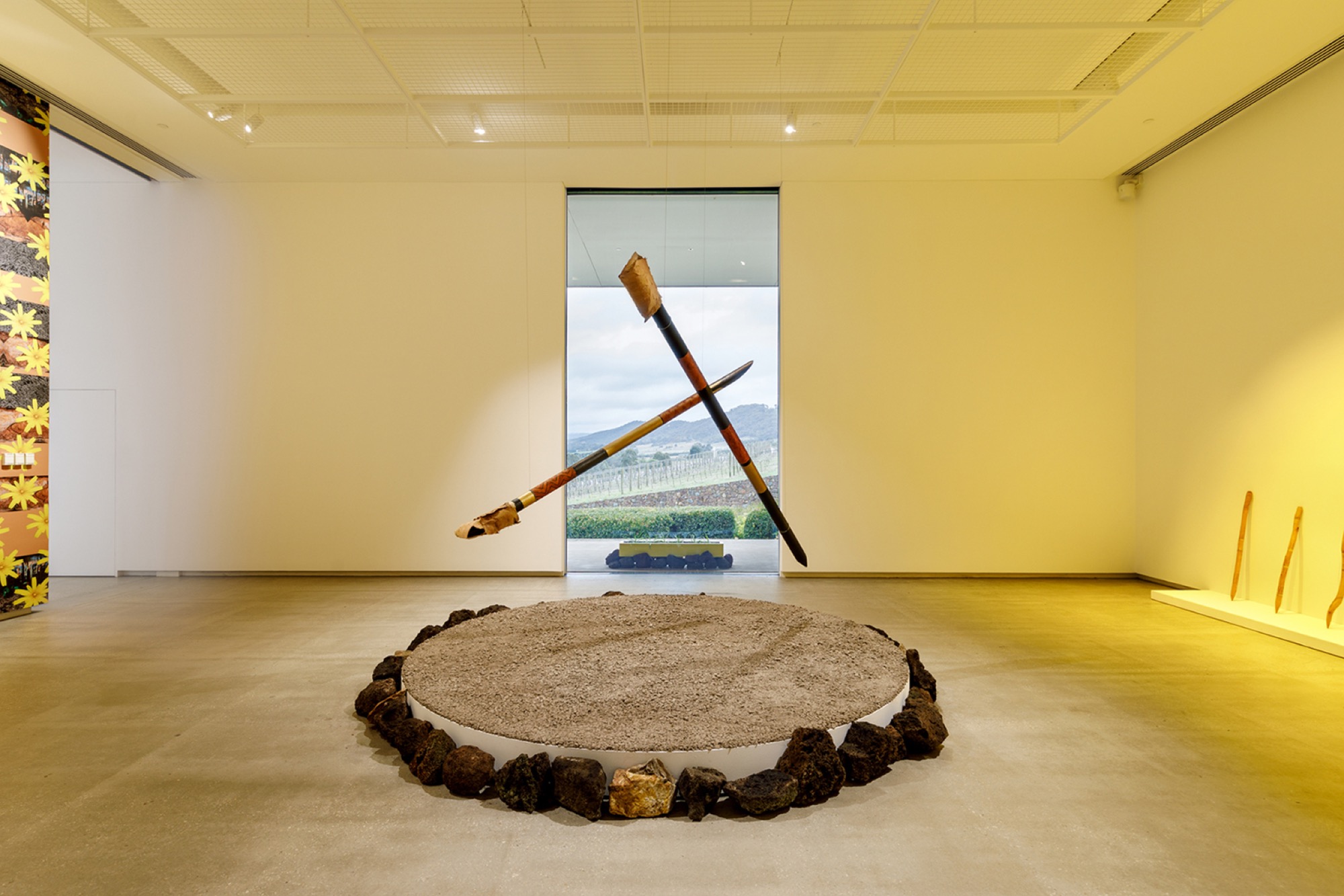 Arika Waulu (Koolyn, Gunnai, Djap Wurrung, Peek Wurrung, Dhauwurd Wurrung), <em>Yuccan Noolert (Mother Possum)</em> 2021, wood, red ochre, yellow ochre, charcoal, acrylic, ink, melaleuca bark, crushed granite, koolor (lava stone) dimensions variable, installation view, WILAM BIIK, TarraWarra Museum of Art, 2021. Courtesy of the artist. Photo: Andrew Curtis.